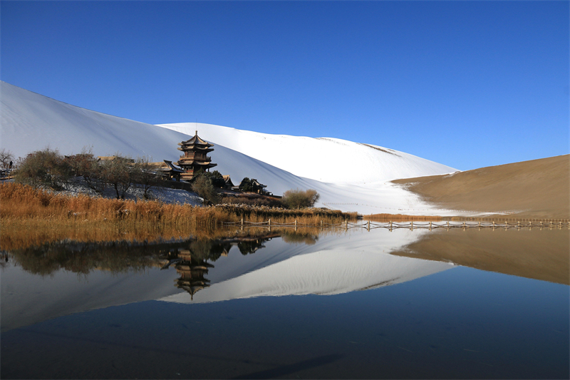 鳴沙山月牙泉景區(qū)雪景。敦煌市委宣傳部供圖，張曉亮攝